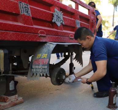 消防隊員用液壓千斤頂給三輪車更換輪胎