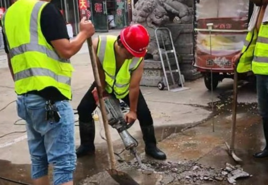 路面狹窄,管道搶修工人使用螺旋千斤頂頂升路面基石